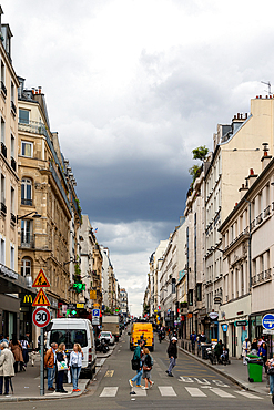 A street view showcases Parisian buildings, pedestrians, vehicles, and a cloudy sky, captured from street level.