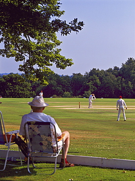 Man watching a game of cricket on Southborough Common, near Tunbridge Wells, Kent, England, United Kingdom, Europe