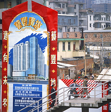 Sign showing modern buildings in front of old huts and apartment blocks in the Shenzhen Development Zone, Guangdong, China, Asia