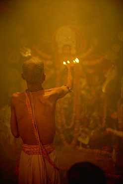 Temple priest before the image of the ten armed warrior goddess Durga, Durga Puja Festival, Varanasi, Uttar Pradesh state, India, Asia