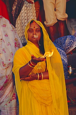 Hindu woman pilgrim holding fire, Varanasi (Benares), Uttar Pradesh State, India