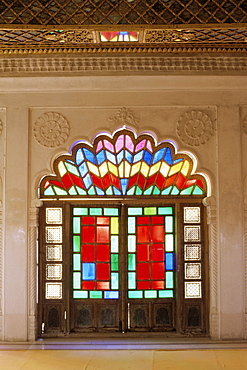 Original old stained glass in doors and decorative jali wood carving in door, Mehrangarh Fort, Jodhpur, Rajasthan state, India, Asia