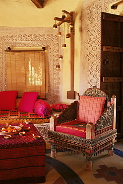 Raised mud reliefs inlaid with mirror on the walls of modern home in traditional tribal Rabari round mud hut, Bunga style, near Ahmedabad, Gujarat state, India, Asia