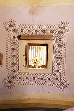 Raised mud reliefs inlaid with mirror on the walls of modern home in traditional tribal Rabari round mud hut, Bunga style, near Ahmedabad, Gujarat state, India, Asia