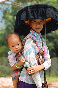 Woman in traditional dress and large black frilled hat, with her baby, in Hong Kong, China, Asia