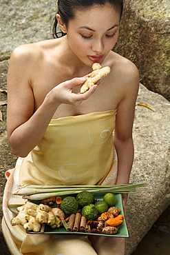 Girl holding a tray full of ingredients for Jamu, the Indonesian herbal elixir, Indonesia, Southeast Asia, Asia