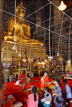 Monk blessing people in the main Viharn of Wat Suthat Bangkok, Thailand, Southeast Asia, Asia