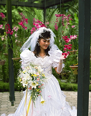 Bride looking at orchids, Asia