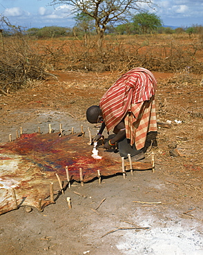 Maasai lady working on animal skin, Kenya, East Africa, Africa