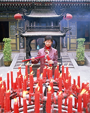 Woman with candle and incense offerings, Big Goose Pagoda temple, Xian, Shaanxi Province, China, Asia