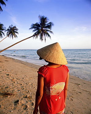 Woman in conical hat walking along the beach, Mui Ne beach, south-central coast, Vietnam, Indochina, Southeast Asia, Asia