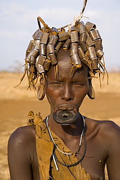 Portait of a Mursi girl with clay lip plate, and hairstyle that indicates she is going through puberty,The Mursi Hills, Mago National Park, Lower Omo Valley, Ethiopia, Africa