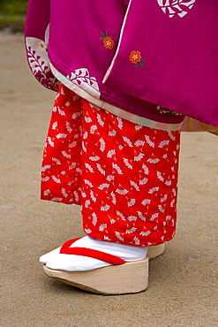 Woman wearing traditional Japanese kimono and okobo (tall wooden shoes), Kyoto, Kansai region, island of Honshu, Japan, Asia