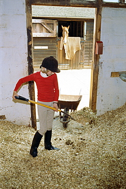 Girl mucking out, Belmont Country Club, England, United Kingdom, Europe