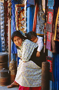 Woman and baby, cloth shopkeeper in temple square, Bodhnath, Kathmandu, Nepal
