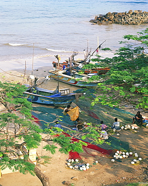 Fishermen mending their nets in the fishing harbour at Galle, Sri Lanka, Asia