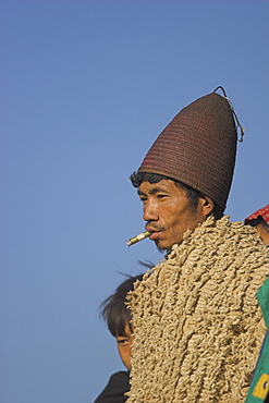 Naga man  wearing cane hat, heirloom blanket and smoking cheroot, Naga New Year Festival, Lahe village, Sagaing Division, Myanmar (Burma), Asia