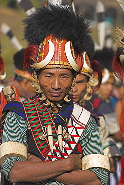 Naga man wearing headdress made of woven cane decorated with wild boar teeth, bear fur, red dyed goats hair with strap of tiger claws also wearing tiger teeth necklace and ivory arm band, Naga New Year Festival, Lahe village, Sagaing Division, Myanmar (Burma), Asia