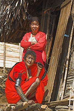 Naga (Macham tribe) ladies outside house, the lady in the foreground has face and leg tattoos, done in childhood so that they are not attractive to men who might steal them from the village, Magyan Village, Sagaing Division, Myanmar (Burma), Asia