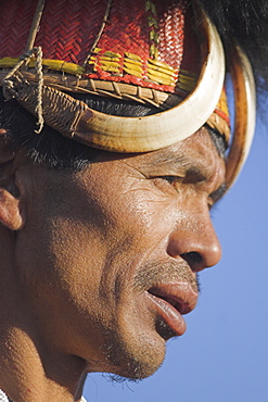 Naga man wearing headdress made of woven cane decorated with wild boar teeth, Mithan horns (wild cow) and bear fur and wearing conch shell ear ornament with a tiger claw, Naga New Year Festival, Lahe village, Sagaing Division, Myanmar (Burma), Asia