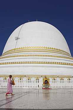 Nun in front of the 46m hemispherical dome at Kaunghmudaw Paya (Rajamanisula pagoda), Sagaing, Mandalay, Myanmar (Burma), Asia