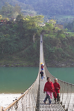 Local people crossing the 160m long suspension bridge, Trisuli Center, Bandare village, Trisuli Valley, Nepal, Asia