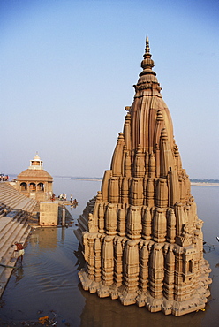 Partially submerged tilted Shiva temple below the ghats on the edge of the River Ganges (Ganga), Varanasi (Benares), Uttar Pradesh, India, Asia