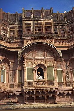 Guard sitting by window, City Palace, Udaipur, Rajasthan state, India, Asia