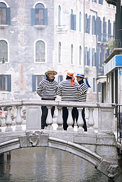 Gondoliers chatting on bridge, near San Marco, Venice, Veneto, Italy, Europe