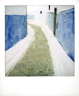 View taken on Polaroid down narrow street showing traditional blue and whitewash, Kasbah des Oudayas, Rabat, Morocco, North Africa, Africa