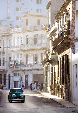 Old American car driving along quiet street in Havana Centro, Havana, Cuba, West Indies, Caribbean, Central America