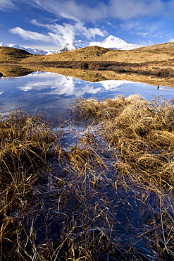 Black Mount Hills covered in snow on a sunny winter's day with reflections in a frozen Lochain, Rannoch Moor, Highland, Scotland, United Kingdom, Europe