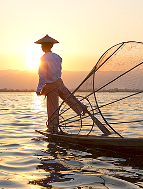 Intha 'leg rowing' fishermen sunset on Inle Lake who row traditional wooden boats using their leg and fish using nets stretched over conical bamboo frames, Inle Lake, Myanmar (Burma), Southeast Asia