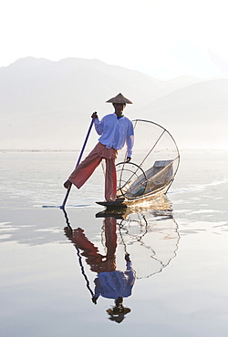 Intha 'leg rowing' fishermen on Inle Lake who row traditional wooden boats using their leg and fish using nets stretched over conical bamboo frames, Inle Lake, Myanmar (Burma), Southeast Asia