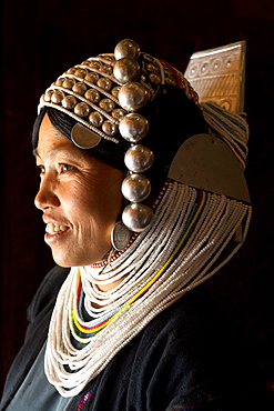 Woman of the Akha tribe in traditional dress including a headdress of heavy silver baubles, in a hill village near Kengtung (Kyaingtong), Shan State, Myanmar (Burma), Asia