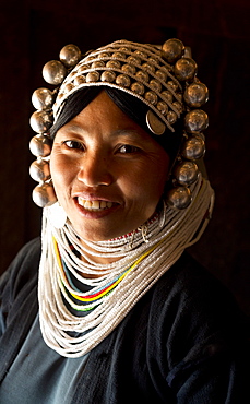 Woman of the Akha tribe in traditional dress including a headdress of heavy silver baubles, in a hill village near Kengtung (Kyaingtong), Shan State, Myanmar (Burma), Asia