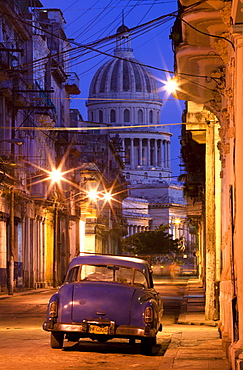 Vintage American car parked on floodlit street with The Capitolio in the background, predawn, Havana Centro, Cuba, West Indies, Central America