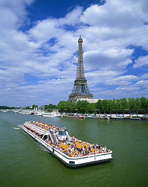 Tourists on bateau mouche on the River Seine with the Eiffel tower in the background, in Paris, France, Europe