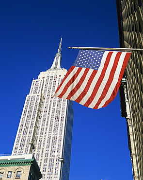 The American flag, the stars and stripes in front of the Empire State Building in New York, United States of America, North America