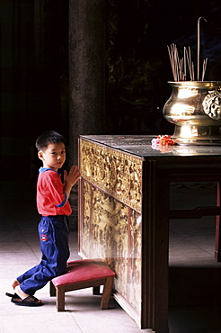 Boy worshipping, Kek Lok Si temple, Air Itam, Penang, Malaysia, Southeast Asia, Asia