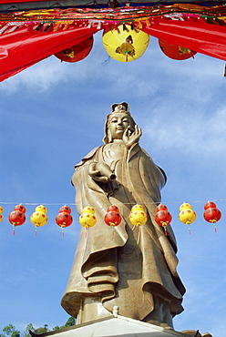 Red and yellow lanterns in front of the standing statue of Kuan Yim, Kuan Yim temple, Penang Island, Malaysia, Southeast Asia, Asia