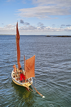 A fisherman sets out in his oyster dredger from Mousehole Harbour, Penwith, Cornwall, England, United Kingdom, Europe