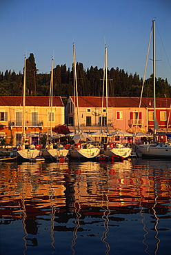 Reflections of boats in the evening at Fiskardo, on Kefalonia, Ionian Islands, Greek Islands, Greece, Europe