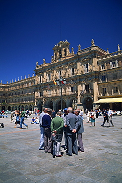 A group of men talking in front of the town hall in the Plaza Mayor, in Salamanca, Castilla y Leon, Spain, Europe