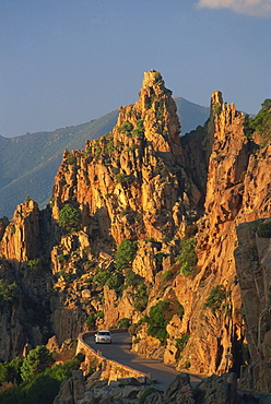 The Calanche, white granite rocks, with car on road below, near Piana, Corsica, France, Europe