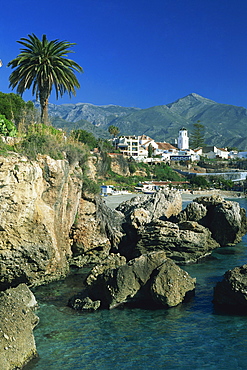 View along rocky coast to town of Nerja and mountains, Costa del Sol, Andalucia, Spain, Europe