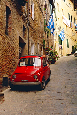 Red car parked in narrow street, Siena, Tuscany, Italy