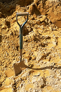 Close-up of spade in sand on a building site, City of London, England, United Kingdom, Europe