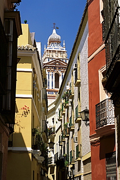 View along narrow street to ornately decorated church, Santa Cruz district, Seville, Andalucia (Andalusia), Spain, Europe