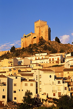 Whitewashed village houses dwarfed by the Castillo de los Fajardo at sunrise, Velez Blanco, Almeria, Andalusia (Andalucia), Spain, Europe